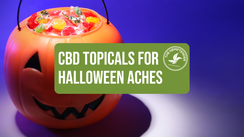 An orange pumpkin-shaped Halloween bucket filled with candy, with a green banner that reads 'CBD Topicals for Halloween Aches' featuring The Hemptender's logo.